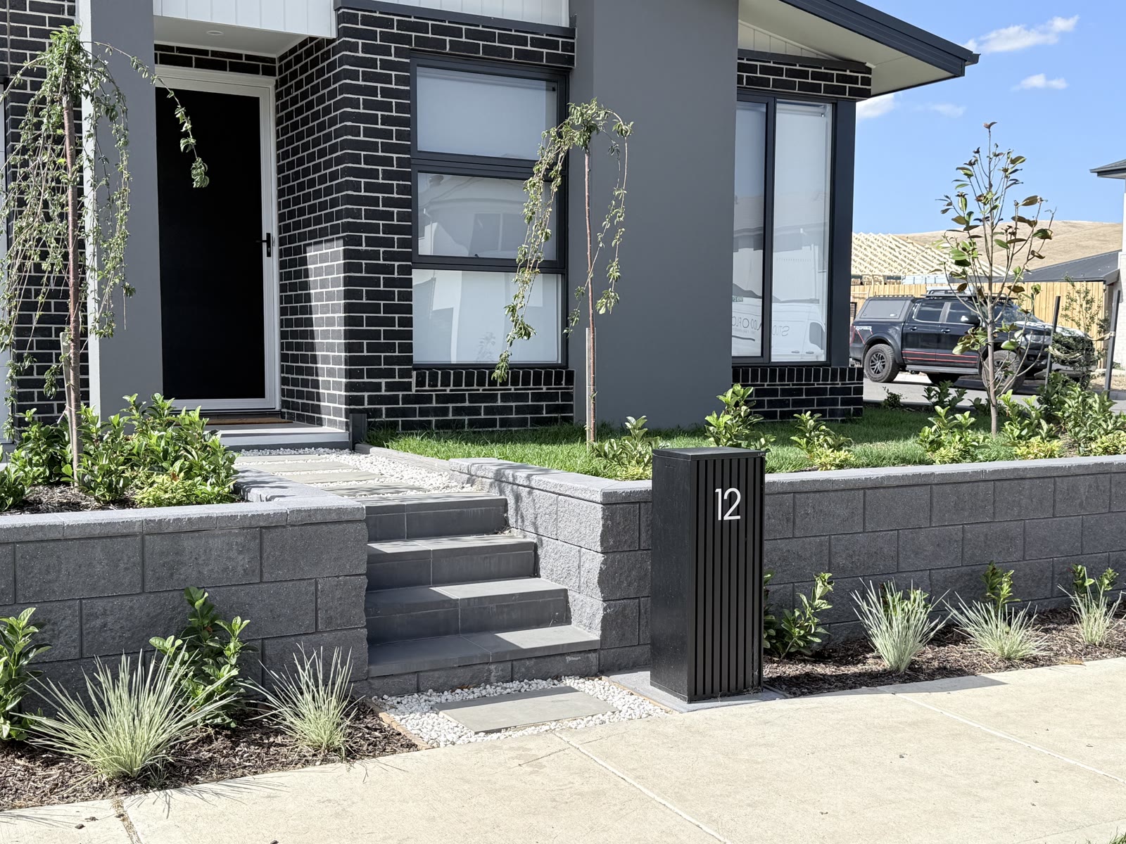 Block retaining wall with built-in steps